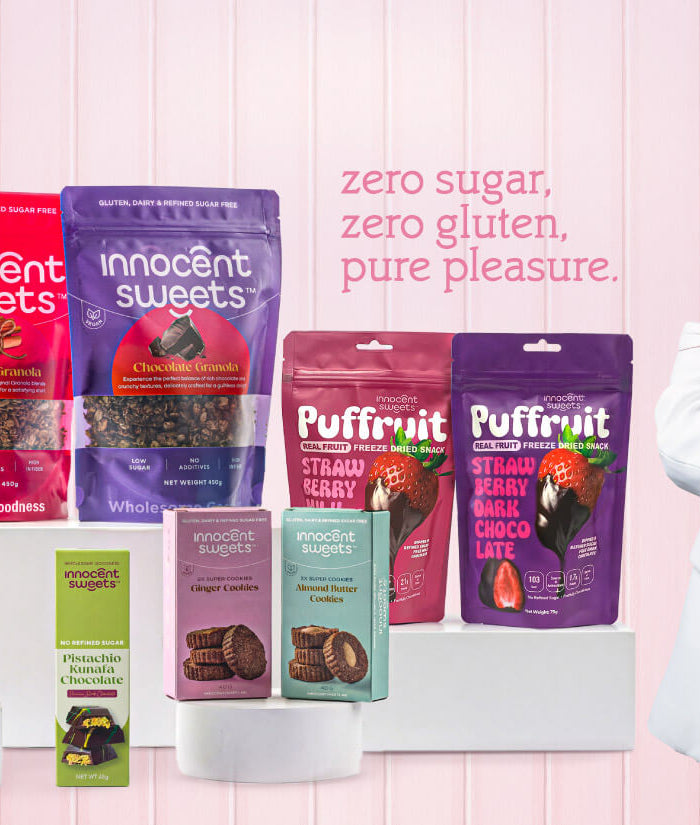 Innocent Sweets products including Puffruit and other snacks on a pink background with Maya Moghrabi, Founder, holding the products. Private label by Flour Girl UAE Dubai Abu Dhabi.