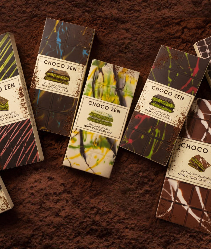 Selection of Chocozen chocolate bars with various designs on a cacao background. Private label by Flour Girl UAE Dubai Abu Dhabi.