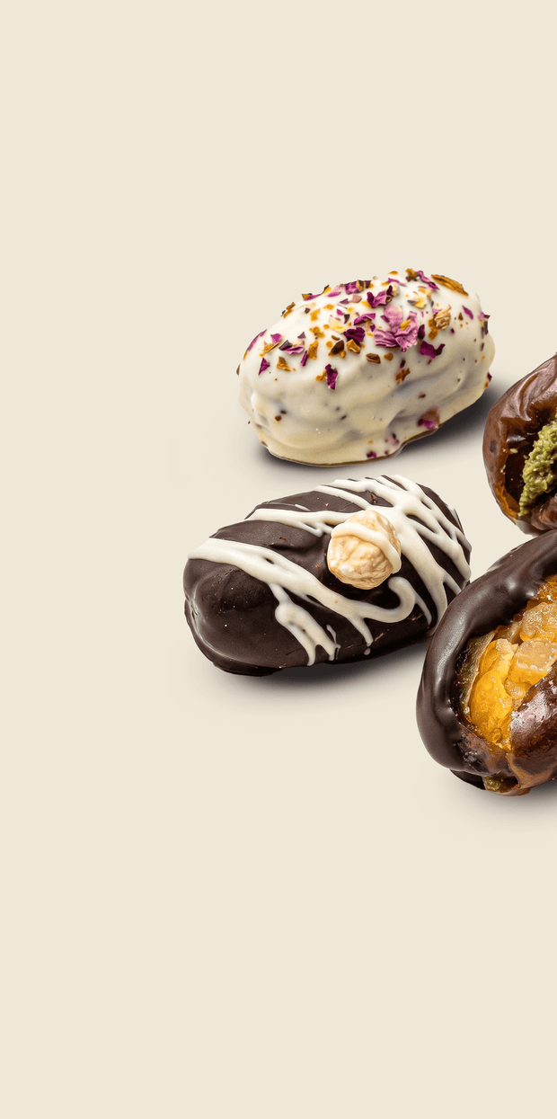 Assorted chocolate-dipped mejdool dates with different toppings on a beige background. Flour Girl Premium Mejdool.